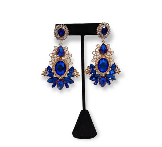 A pair of earrings with blue and white gold pearls, and cubic zirconia embellishments.